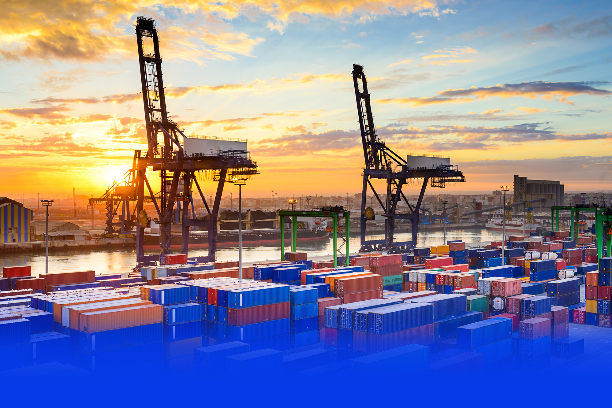 Containerhafen mit Verladekränen im Sonnenuntergang